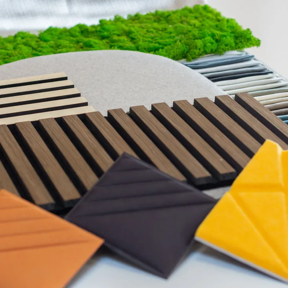 Campioni acustici Silenzia: listelli di legno, pannello beige e campioni colorati con arancione, blu e giallo, più tappetino verde muschio.
